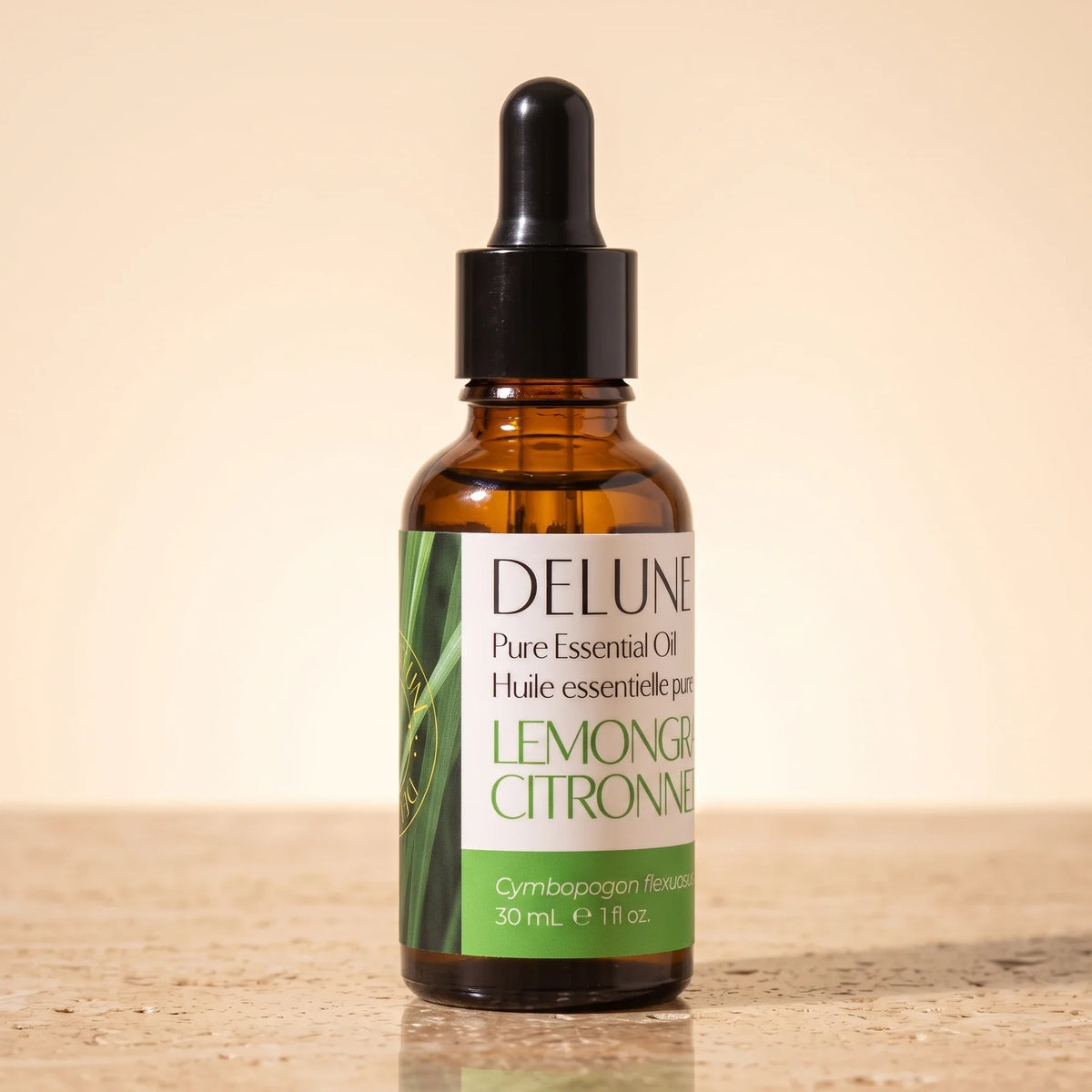 Delune Lemongrass Pure Essential Oil, 30ml amber glass dropper bottle on warm travertine stone