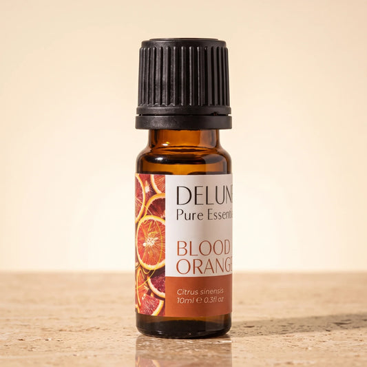 Delune Blood Orange Pure Essential Oil, 10ml amber glass bottle on warm travertine stone