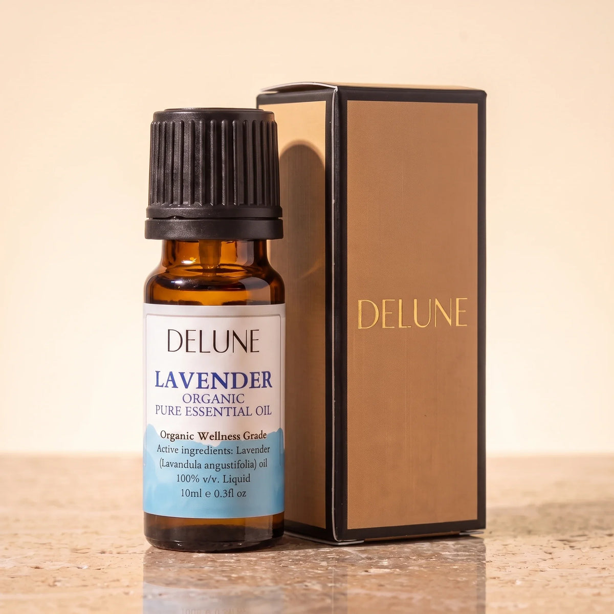 Delune Lavender Organic Wellness Grade Essential Oil, 10ml amber glass bottle with its gold-foil Delune gift box on warm travertine stone