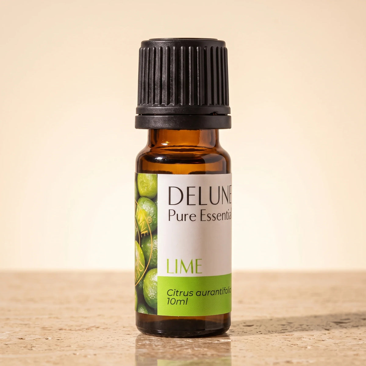 Delune Lime Pure Essential Oil, 10ml amber glass bottle on warm travertine stone