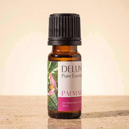 Delune Palma Rosa Pure Essential Oil, 10ml amber glass bottle on warm travertine stone