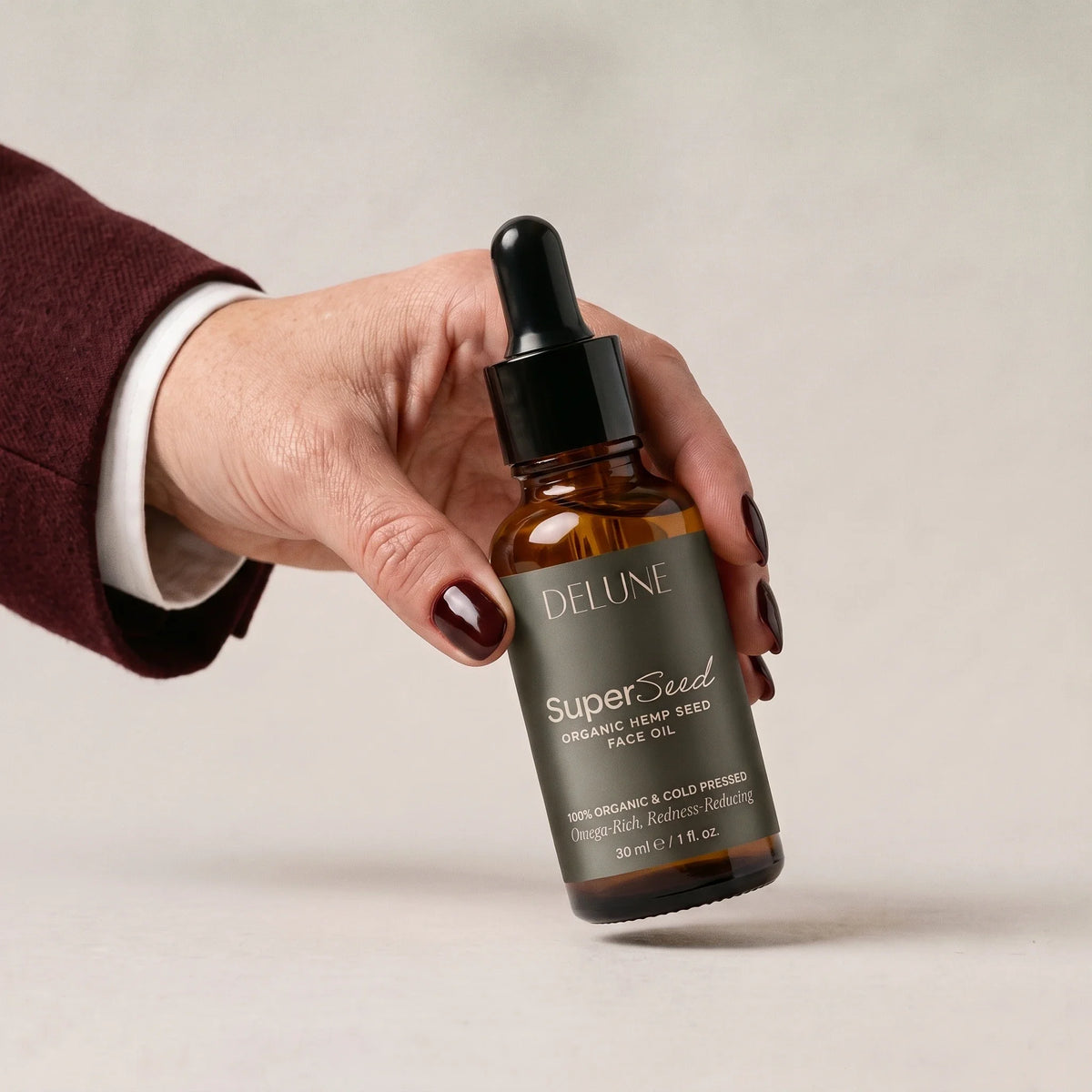 Hand picking up Delune Super Seed Hemp Seed Face Oil