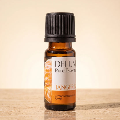 Delune Tangerine Pure Essential Oil, 10ml amber glass bottle on warm travertine stone